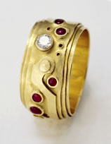  A 'Coiled Ring' in 18K gold with a diamond and small Ruby cabochons